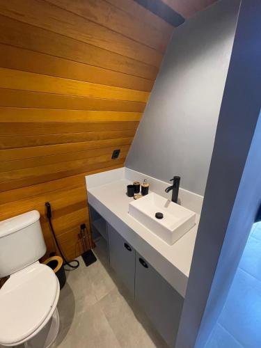 a bathroom with a white toilet and a sink at Pousada Motta in Miguel Pereira
