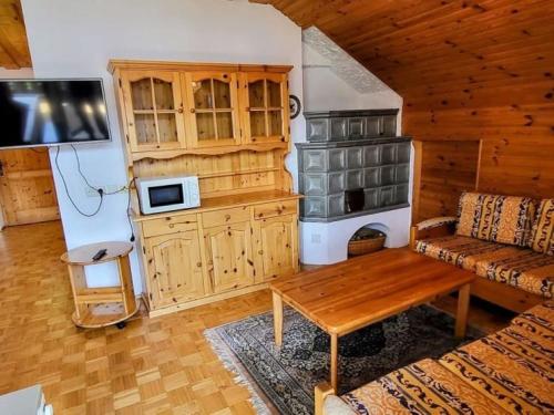 a living room with a couch and a stove at Pension Sedlak in Millstatt