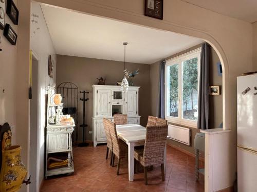 une salle à manger avec une table et des chaises blanches dans l'établissement Séjour plage en tribu, Maison Étoile Pascale Confort convivialité, proximité mer À 5 min de la plage de Trojan les Bains, Parfait pour week-end ou vacances en groupe, à Saint-Trojan-les-Bains