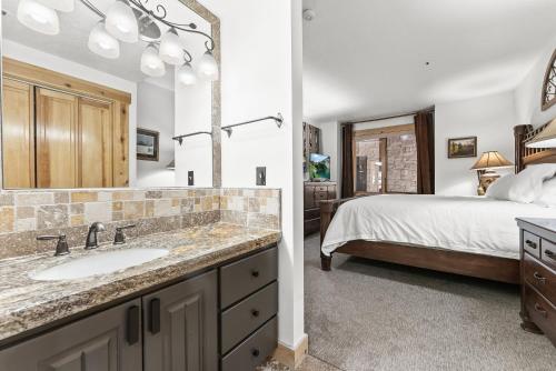 een badkamer met een wastafel en een slaapkamer met een bed bij Deer Valley Luxury Condo, Comstock Lodge, 2 Bedroom - Walk to Lifts, Private Hot Tub, Amazing Views in Park City