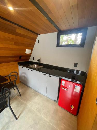 a kitchen with a red refrigerator and a sink at Pousada Motta in Miguel Pereira
