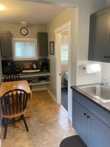 a kitchen with a table and a chair and a sink at Elmwood Motor Court in Old Orchard Beach