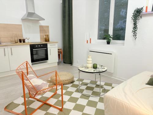 un salon avec une table et des chaises et une cuisine dans l'établissement Appartement dans le cœur de Pau, à Pau