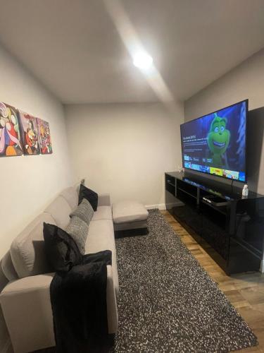 a living room with a white couch and a flat screen tv at New Modern Apartment in Yonkers
