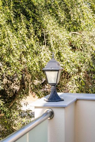 a blue light on a white fence with trees at Olive Studios Karpathos Studio #1 in Karpathos Town