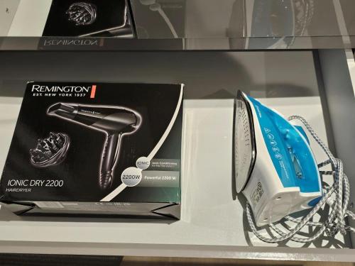 a new iron and a box on a shelf at Blue Garden Retreat by Fortuna Property Portfolio in Cheltenham