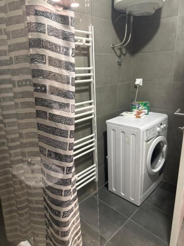 a shower curtain in a bathroom with a washing machine at Elma Meandar otoka in Sarajevo