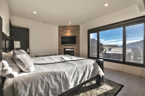 a bedroom with a large bed and a large window at Juniper Landing - Luxury Townhouse - Outdoor Pool, Gym, Hot Tub in Canyons Village in Park City