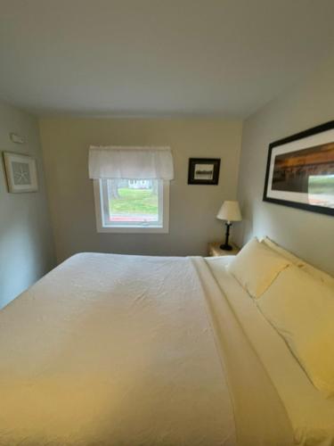 a bedroom with a white bed and a window at Elmwood Motor Court in Old Orchard Beach