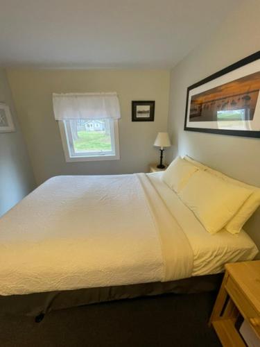 a bedroom with a white bed and a window at Elmwood Motor Court in Old Orchard Beach