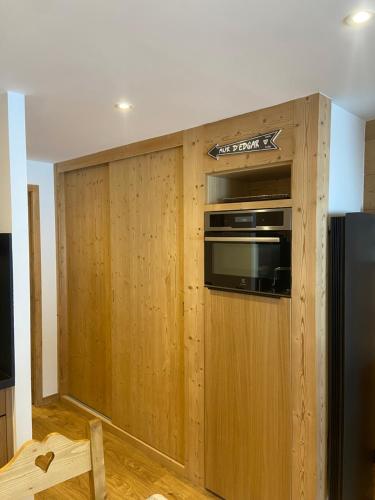 Il comprend une cuisine dotée d'un mur en bois et d'un four micro-ondes. dans l'établissement Everest Appt 6 pers ski aux pieds, à La Clusaz