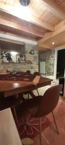a wooden table in a room with a stone wall at Point of view 1 in Pramanta