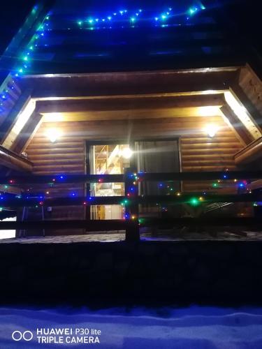 a house with christmas lights on the side of it at Vila Dajana Zminica in Žabljak