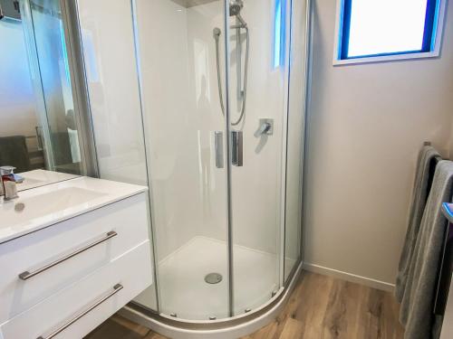 a bathroom with a shower and a white sink at Country Cottage in Sefton