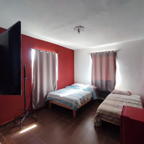 ein Zimmer mit zwei Betten und einem Flachbildfernseher in der Unterkunft Casa texcoco in Cabo San Lucas
