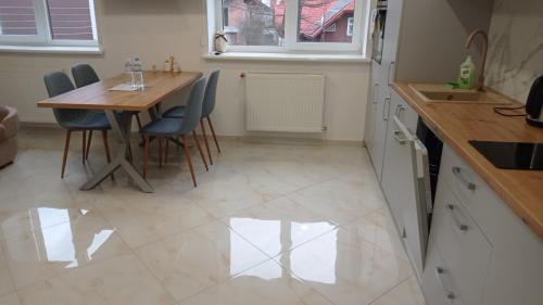 a kitchen with a table and chairs and a sink at ApartPlus Truskavets - Затишні апартаменти in Truskavets