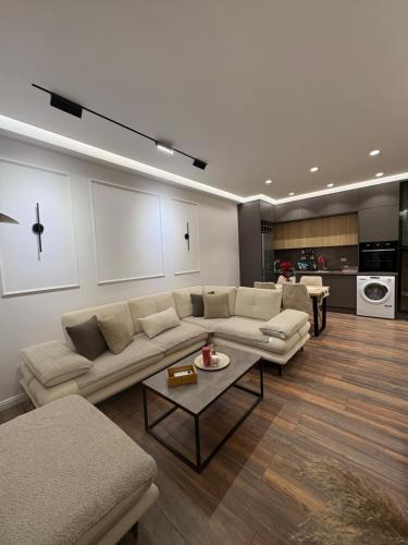 un salon avec un canapé et une table dans l'établissement Alajs Apartament, à Vlorë