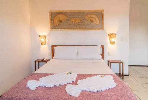 a bedroom with a bed with two towels on it at Pousada Villa Tomasi in Jericoacoara