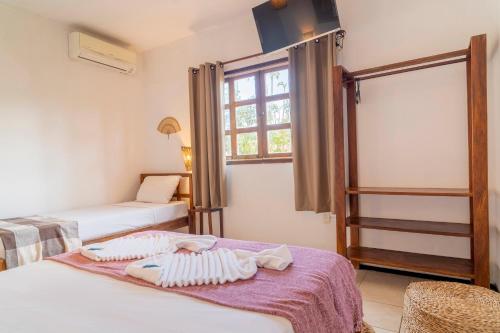 a bedroom with two beds and a window at Pousada Villa Tomasi in Jericoacoara