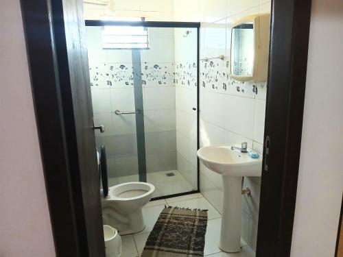 a bathroom with a shower and a toilet and a sink at CASA COM SPA DE HIDRO, AQUECEDOR E CROMOTERAPIA A 1,0 kM DO CENTRO in Chapada dos Guimarães