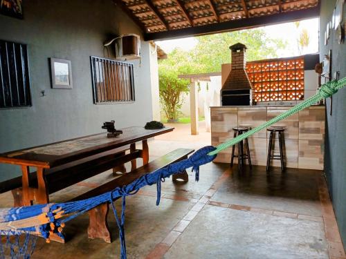 a patio with a wooden table and a stove at CASA COM SPA DE HIDRO, AQUECEDOR E CROMOTERAPIA A 1,0 kM DO CENTRO in Chapada dos Guimarães