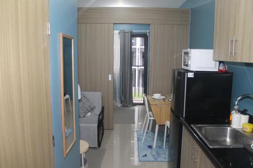 a small kitchen with a refrigerator and a table at Shore 2 Residence Tower 2 in Manila