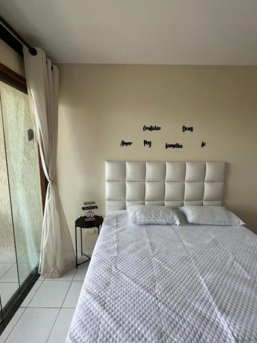 a bedroom with a bed with words on the wall at Flat monte castelo condomínio in Bezerros