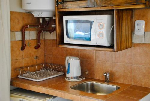 a kitchen counter with a sink and a microwave at ENTRECERROS, Tilcara in Tilcara
