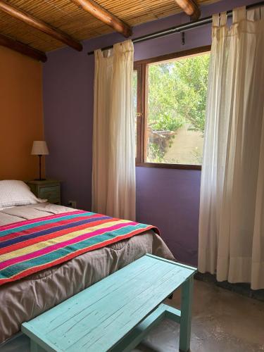 a bedroom with a bed and a window at ENTRECERROS, Tilcara in Tilcara