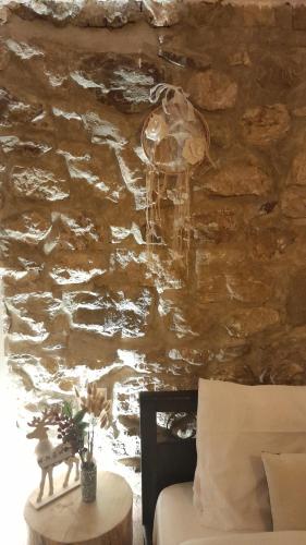 a stone wall with a table next to a bed at Point of view 1 in Pramanta