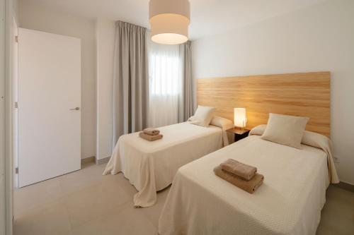 アレシーフェにあるGeria - Panasco Suitesのホテルの部屋にはタオルが敷かれたベッドが2つある