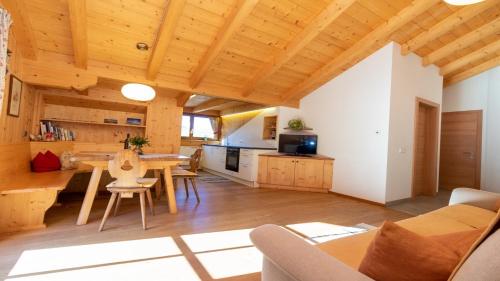 a kitchen and dining room with a wooden ceiling at Spinuserhof in Tires