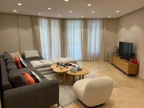 ein Wohnzimmer mit Sofa und Fernseher in der Unterkunft Sea View Haven at Mangroovy in Hurghada