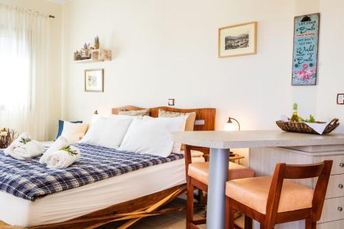 a bed in a room with a table and chairs at Olive Studios Karpathos Studio #1 in Karpathos Town