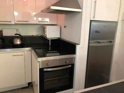Il comprend une petite cuisine équipée d'une cuisinière et d'un réfrigérateur. dans l'établissement location appartement 93 M2 plein centre historique, à Rouen