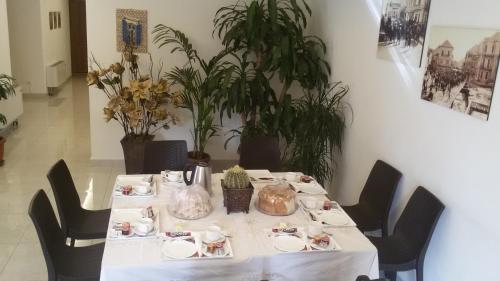 einen Tisch mit einem weißen Tischtuch, Stühlen und Pflanzen in der Unterkunft Hotel St Jean in Zahlé