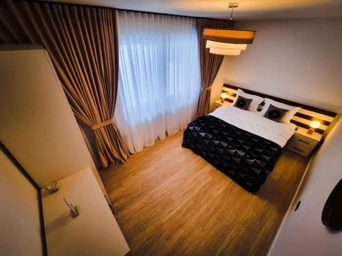 ポイアナ・ブラショフにあるCozy Retreat Grand Chalet Aparthotelのベッドと大きな窓のある寝室