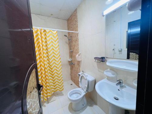 a bathroom with a toilet and a sink at Feel of Home in Ras al Khaimah