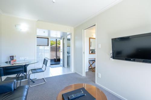 a living room with a flat screen tv on a wall at Admirals Motor Inn in Nelson