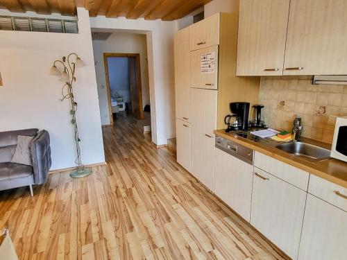 a kitchen with white cabinets and a wooden floor at Pension Sedlak in Millstatt