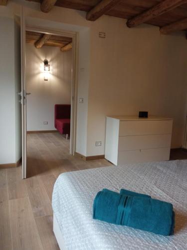 a bedroom with a white bed and a red couch at Appartamento 2 Sottocastello in Pieve di Cadore