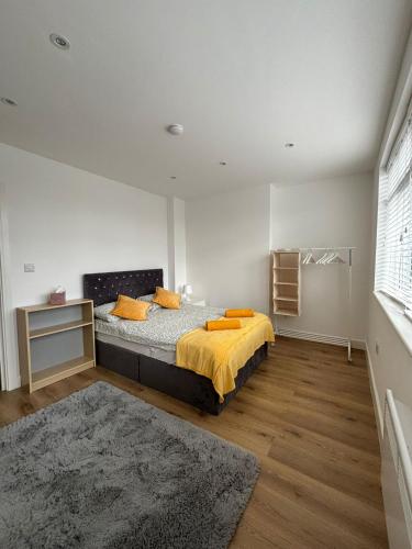 a bedroom with a bed with orange pillows on it at Beatiful 3 bedroom apartment near Tower Bridge in London