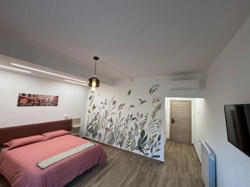 a bedroom with a pink bed and a wall at La dimora di Ipno in Vallata
