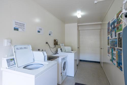 a laundry room with a washing machine and a washer at Admirals Motor Inn in Nelson
