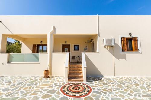 a white house with a staircase and a floor at Olive Studios Karpathos Studio #1 in Karpathos Town