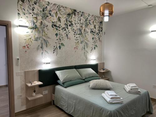 a bedroom with a bed with a floral mural on the wall at La dimora di Ipno in Vallata