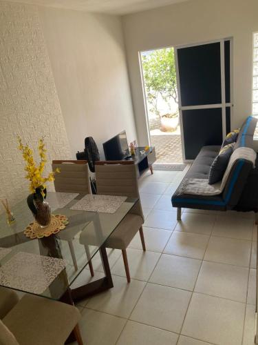 a living room with a table and a couch at Economize e aproveite a região ou descanse para o voo - 24h in Maceió