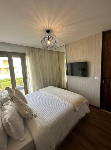 a bedroom with a large white bed and a chandelier at La perle du carrousel in Rabat