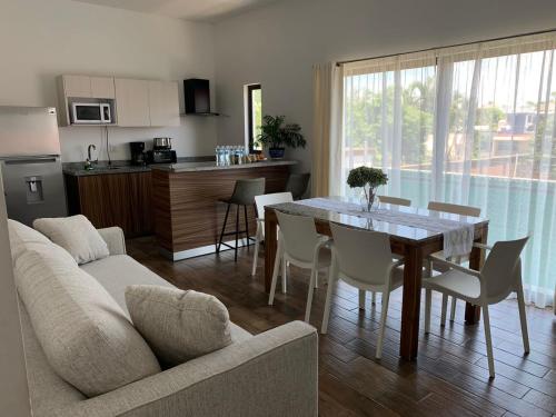 a living room and kitchen with a table and a couch at Condominio Mar y Arena in Mazatlán