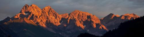 a large mountain range with the sun shining on it at Gschwenderhaus Ferienwohnungen in Oberstdorf